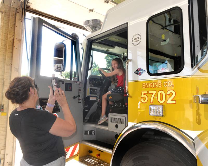 Iris Church, 8, of Sterling, sits in the driver's seat of a Mt. Morris fire engine as her grandmother, Beverly Jackson, also of Sterling, takes a photo during on July 4 during the Mt. Morris Fire Department's annual Pancake and Sausage Breakfast. Fire trucks and other emergency vehicles were on display during the event which was held at the fire station held during the Let Freedom Ring festival.