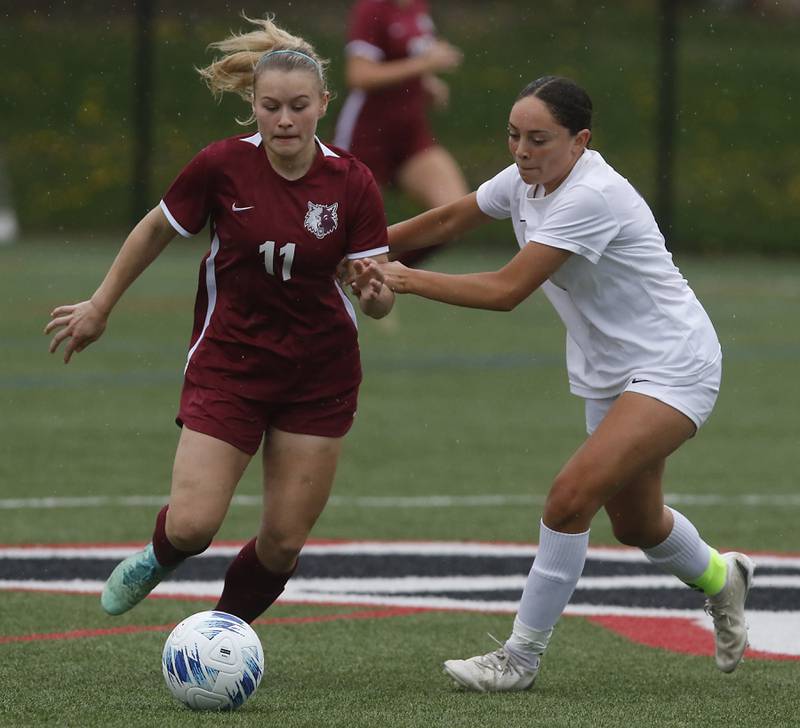 Prairie Ridge's Maria Falkowska tries to control the ball as she is defended by Hampshire's Helen Negron during a Fox Valley Conference soccer game on Tuesday, April 16, 2024, at the MAC Athletic Complex in Crystal Lake.