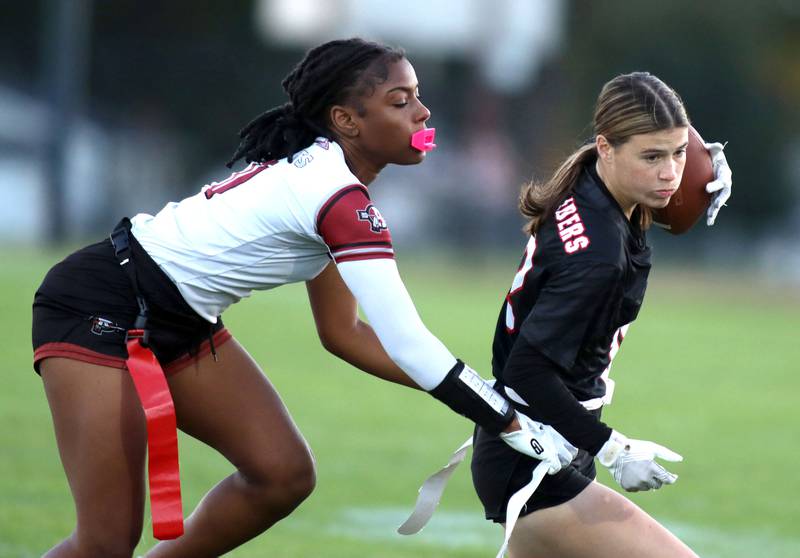 Huntley’s Aubrina Adamik, right, tries to get past Antioch’s Sasha Johnson in IHSA Regional varsity flag football action at Crystal Lake Central High School in Crystal Lake on Wednesday, Oct. 8, 2025.