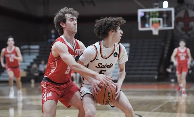St. Charles East’s Jake Greenspan spins away from Naperville Central’s Jonathan Boomgarden in a boys basketball game in St. Charles on Wednesday, January 25, 2023.