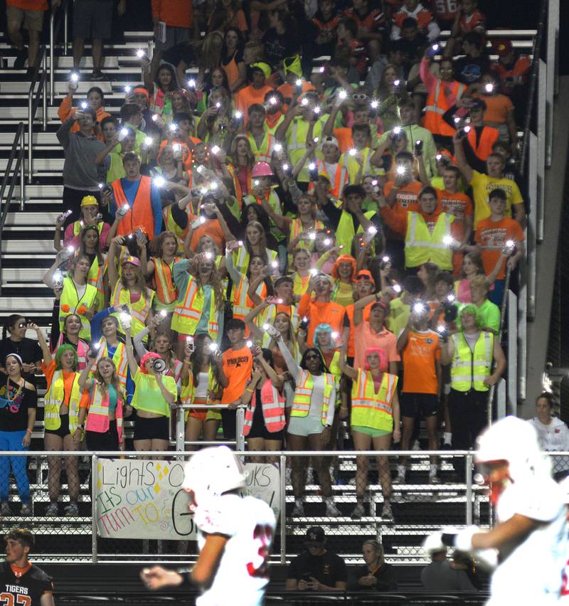Byron High School's student section wave their lighted phones as they cheer on the Tigers in their 35-7 win over the Hawks on Friday, Sept. 12, 2025 at Everett Stine Stadium in Byron. The sign said "Lights Out Hawks. It's our time to glow".