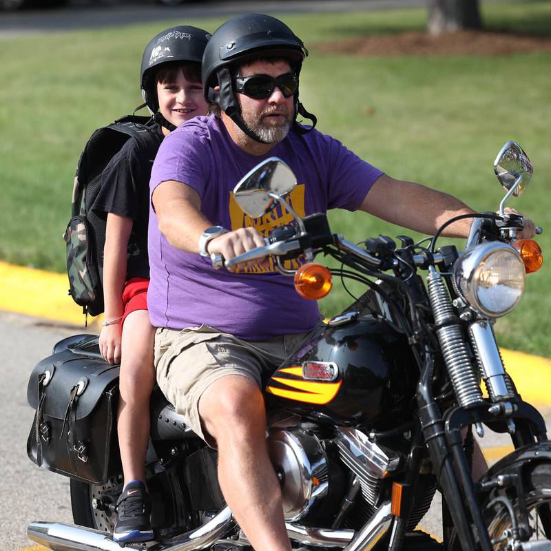 Ryder Davis, a third grader at Southeast Elementary School, arrives in style on the back of his dad Brian’s Harley Davidson for his first day of classes Thursday, Aug. 21, 2024, at the school in Sycamore.