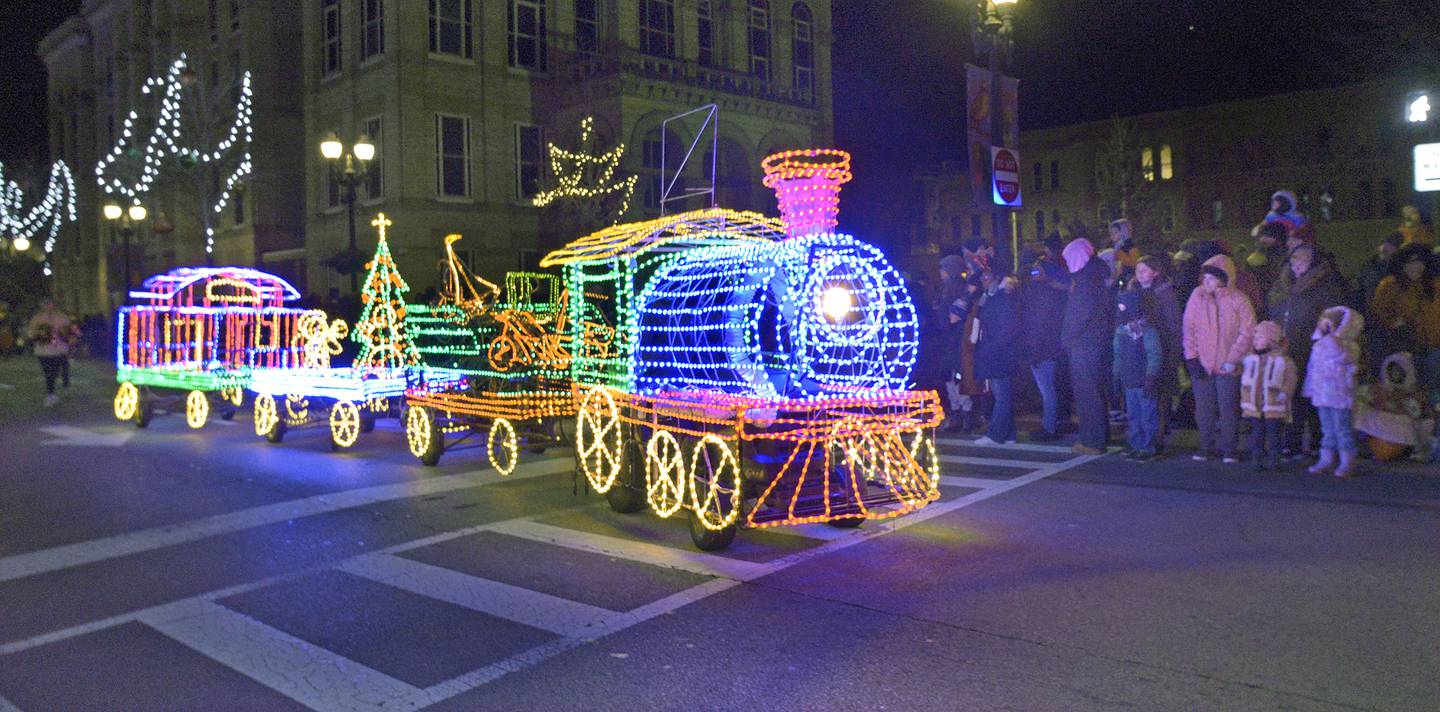 A lighted up Christmas train entertains the crowd gathered along La Salle St in Ottawa Friday during the Festival of Lights Parade.