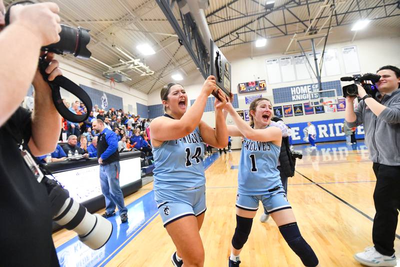 Cissna Park seniors Autumn Reutter, left, and Julia Edelman celebrate as they bring the IHSA Class 1A Blue Ridge Super-Sectional plaque to their teammates following the Timberwolves' 47-35 victory over St. Teresa on Monday, March 3.