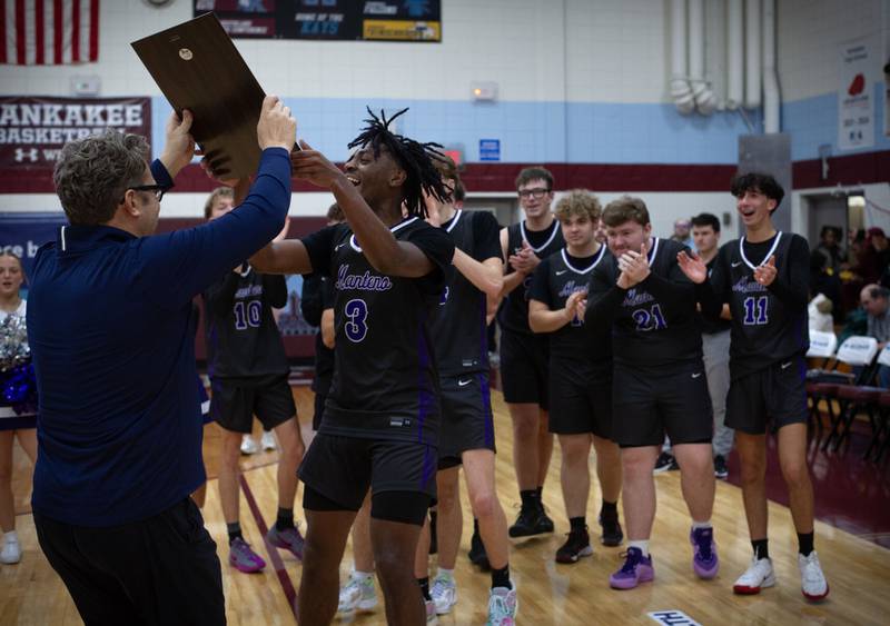 Manteno's Ray Lee receives the championship plaque (blue division) from Bill Yohnka, left, after defeating Joliet Catholic Academy in Saturday's Kankakee Holiday Tournament.