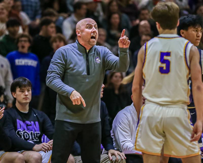 Downers Grove North's head coach Jim Thomas yells instructions during basketball game between Downers Grove South at Downers Grove North. Dec 16, 2023.
