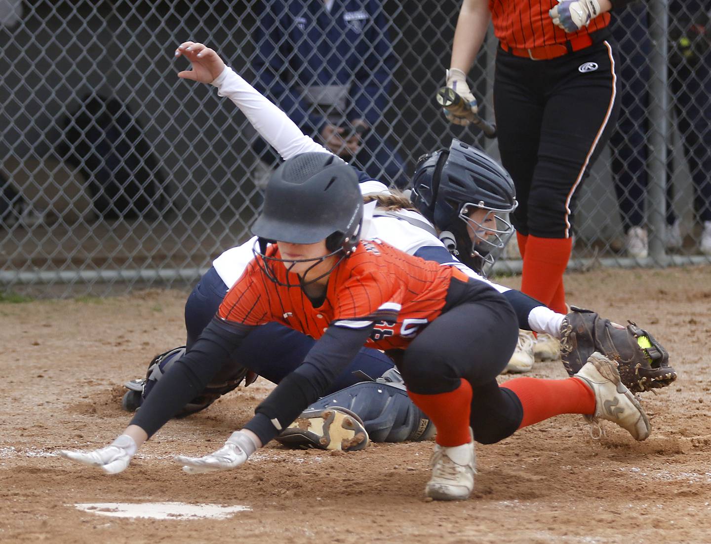 McHenry’s Tatum Kornfeind dives into home as Cary-Grove’s Madilynn Crick tries to tag her during a Fox Valley Conference Softball game Monday, May 2, 2022, between Cary-Grove and McHenry at Cary-Grove High School.