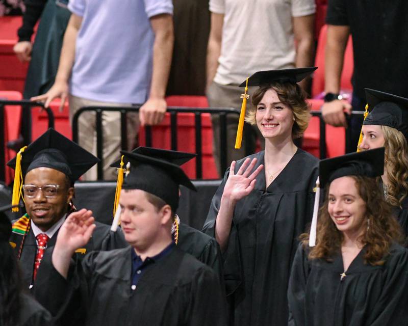 Northern Illinois University graduates wave to family and friends as they enter the arena for graduation on Saturday May 10, 2025, held at the Convocation Center in DeKalb.