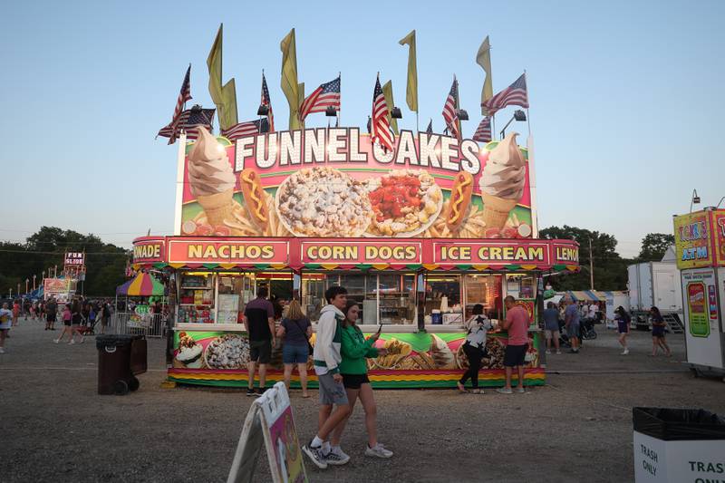 Several people get Funnel Cake, a carnival staple, at Lockport’s Canal Days on Friday, June 9, 2023.