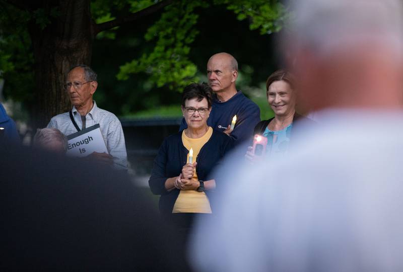 Susan Russo of Batavia holds a candle at a candlelight vigil at the Kane County Courthouse in Geneva on Wednesday, July 6, 2022. The vigil was organized to honor the mass shooting at a Fourth of July Parade in Highland Park.