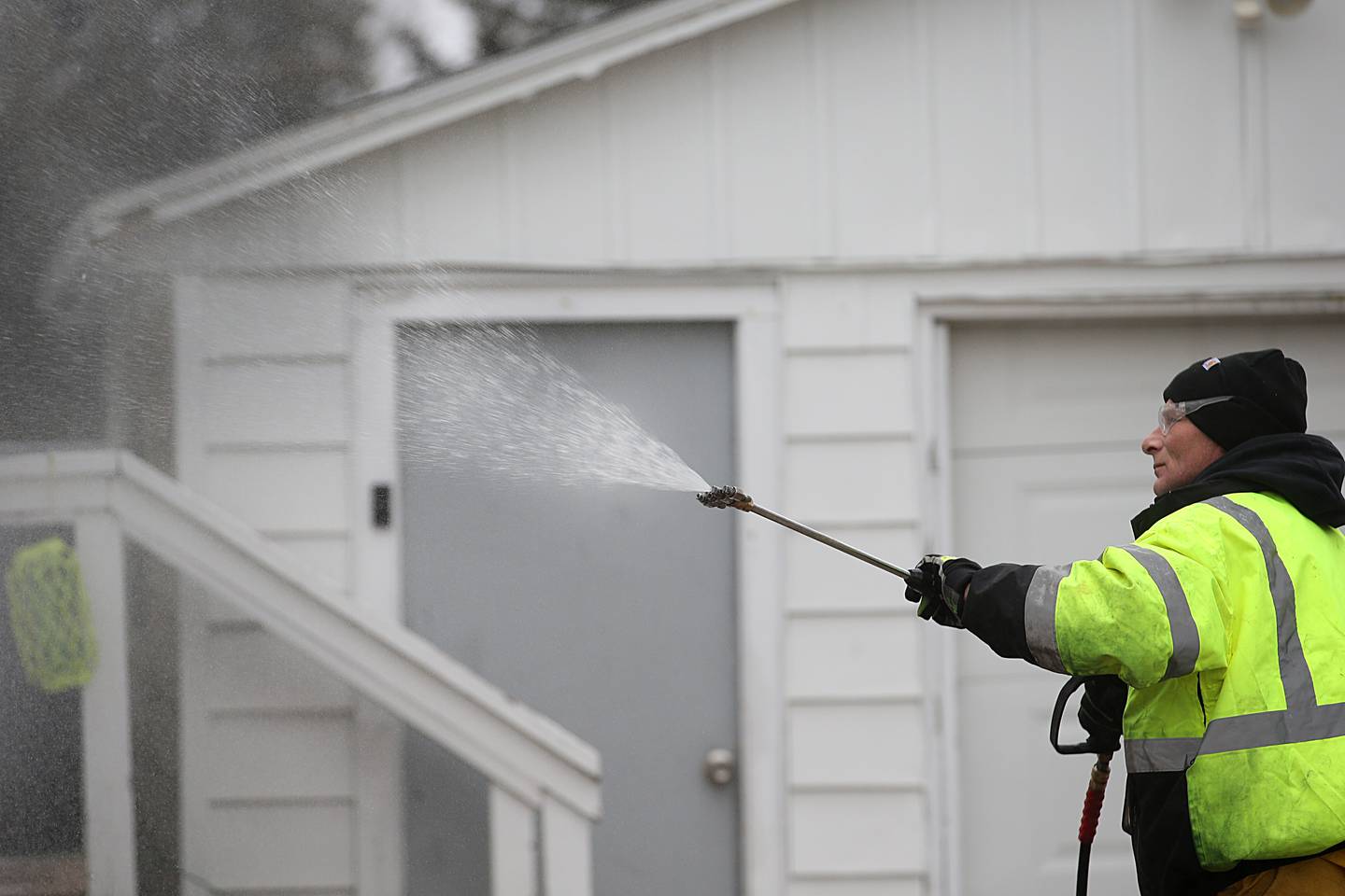 Jim Mennie owner of Precision Washing Exterior Washing, uses a power washer to rinse off the siding of a home on Porter Street on Wednesday, Jan. 18, 2023 in La Salle. Residences who were affected by the Carus Chemical fire can have their homes washed. Carus has approved contractors available to assist with washing. Contact the Carus hotline at 815-224-6662 to get on their list.