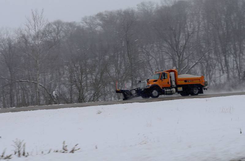 A snow plow sprays salt along Interstate 180 on Monday, Dec. 1, 2025 near Hennepin.