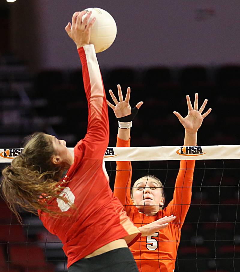 Mother McAuley's Ellie White (8) sends a kill past St. Charles East's Sarah Musial in the Class 4A semifinal game on Friday, Nov. 11, 2022 at Redbird Arena in Normal.