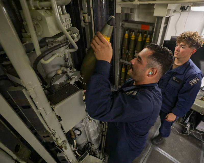 (From left) Gunner’s Mate Second Class Emilio Arroyo, from St. Charles, Ill., and Gunner’s Mate Seaman Daniel Martin, from Cedar Rapids, Iowa, move ammunition from a MK 45 5-inch gun aboard the USS Princeton (CG 59), on Jan. 6, 2025.