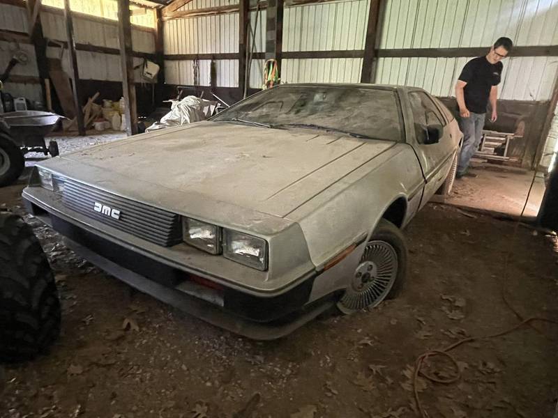 Michael McElhattan of DeLorean Midwest looks over the DeLorean that was sitting in a barn in Wisconsin for about 15 years.