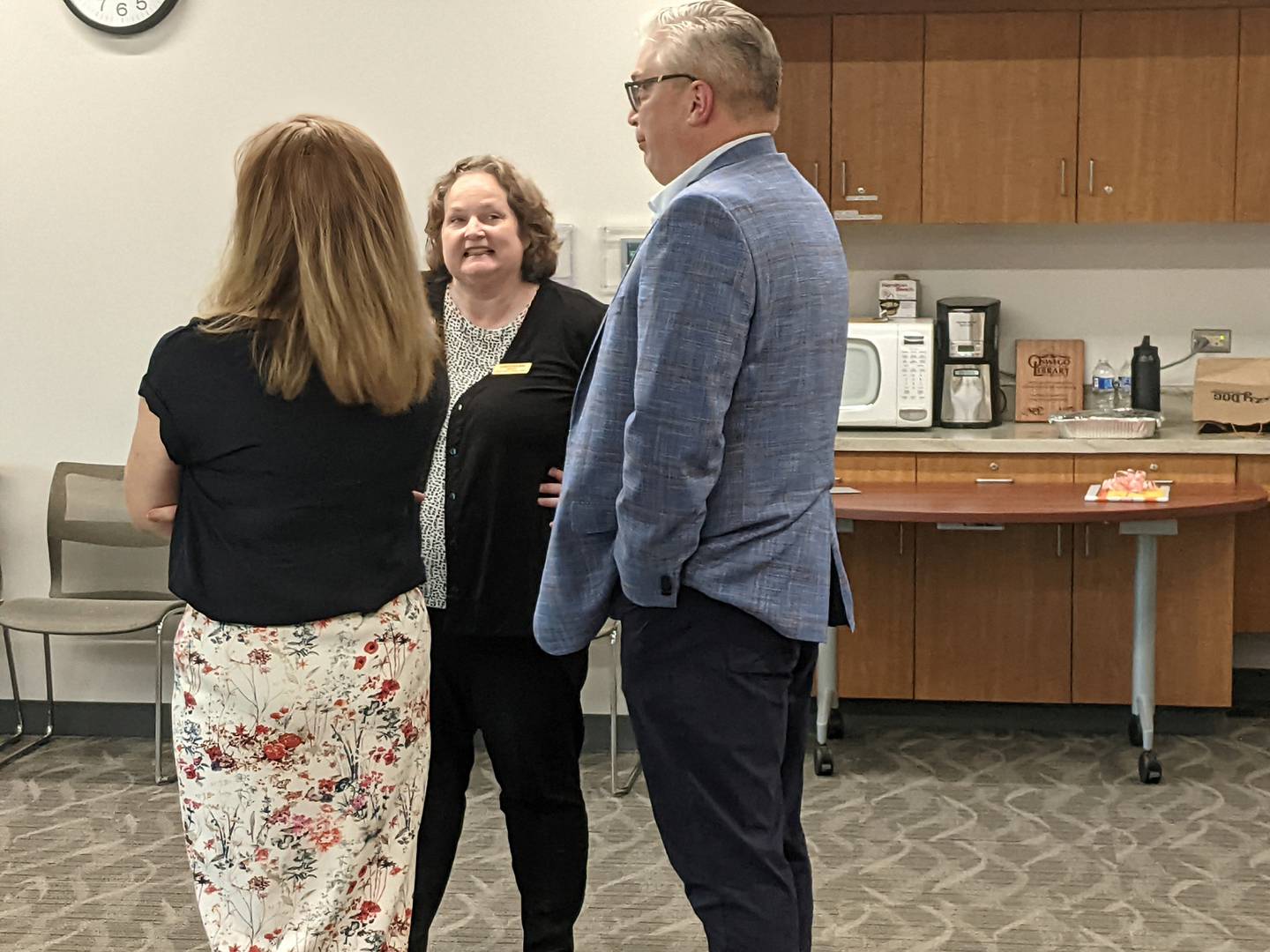 Oswego Public Library District Director Sarah Skilton talks to Oswegoland Park District Rrecreation Director Kristie Vest, left, and  Oswegoland Parks & Planning Director Chad Feldotto,, right, during her retirement party at the downtown Oswego library on Sept. 19, 2025.
