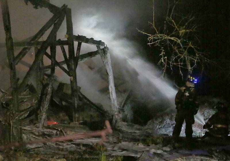 Firefighters spray water on wooden beams of a structure to fight a barn fire located in the 19000 block of 1725 East Street on Thursday, May 9, 2024 near Princeton. A box alarm was sent out shortly after 9:30p.m. for Bureau County fire units.