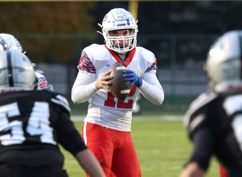 Lakes’ Ean Ankney looks for an open receiver in the Kaneland coverage Saturday, Nov. 1, 2025, during their first round playoff game at Kaneland High School in Maple Park.