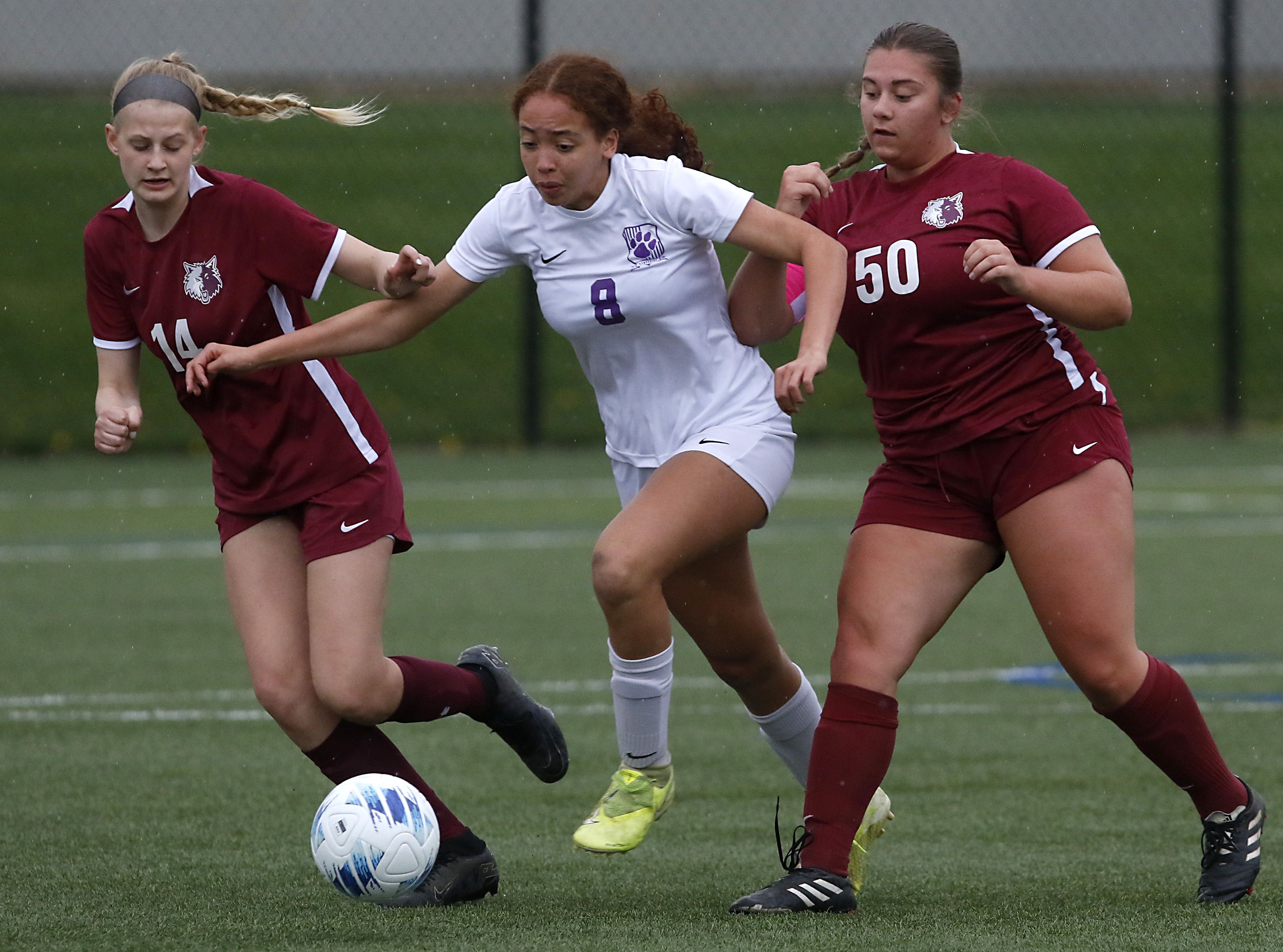 Hampshire's Mikala Amegasse tries to control he ball between Prairie Ridge's Sarah Mayes, left, and Grace Wolf during their Fox Valley Conference match on Tuesday at the MAC Athletic Complex in Crystal Lake.