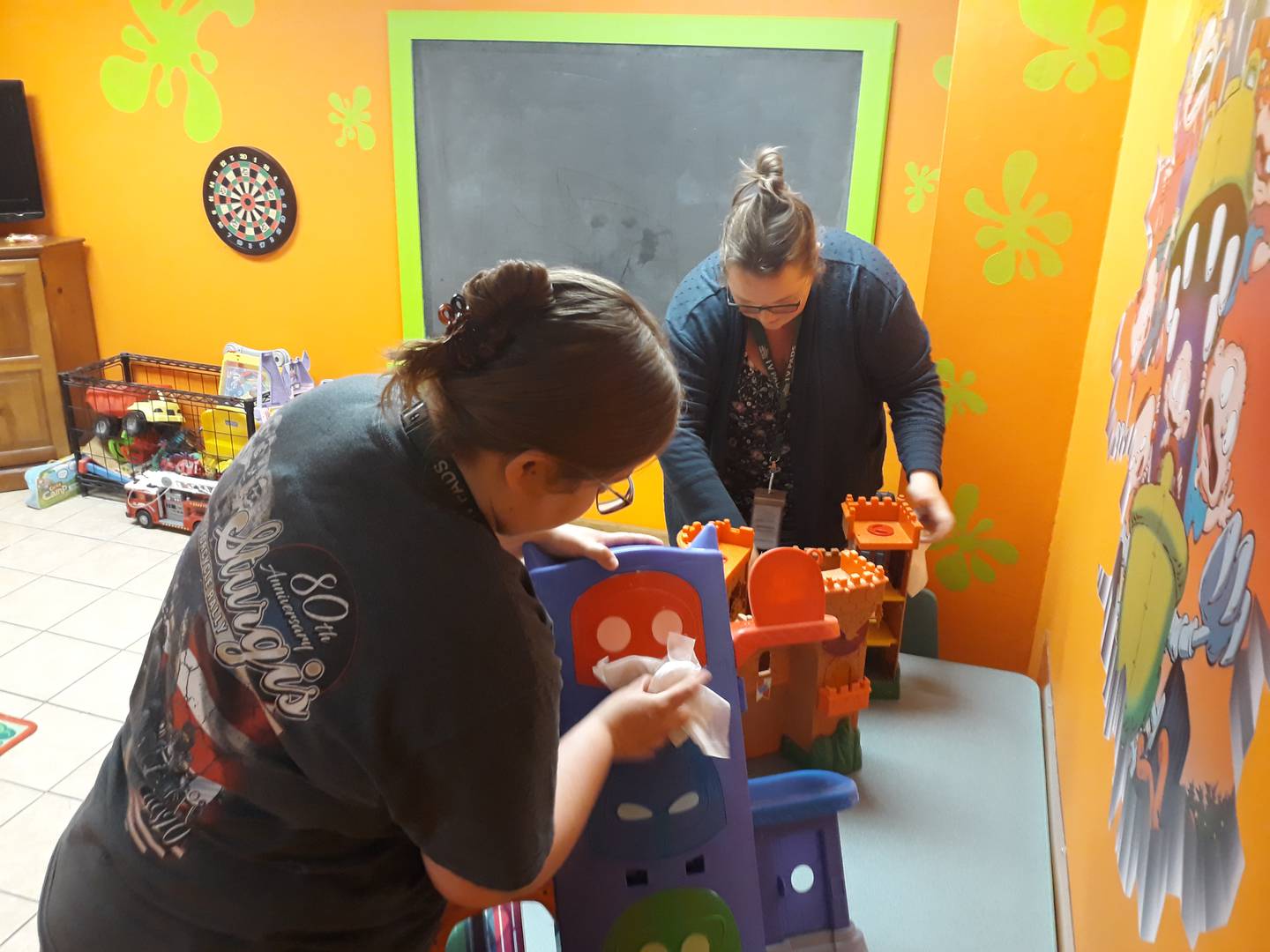 (Left to right) Brittany Smith, case manager at the Illinois Valley Public Action to Deliver Shelter, and Marissa Trumper, program director at PADS, wipe down toys with sanitary wipes in preparation for the Ottawa shelter's opening Monday, Aug. 15, 2022.