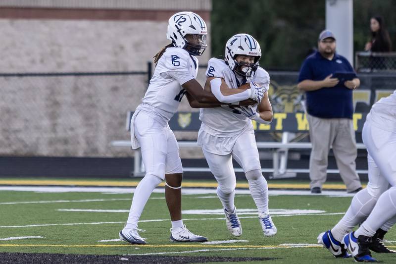 Plainfield South's Jaleel Smith hands-off to Chase Pierceall  during a varsity football away game against Joliet West on Sept. 12, 2025.