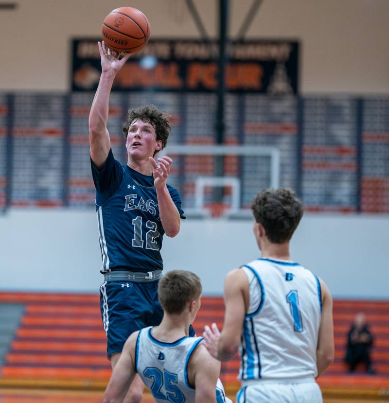 Oswego East's Ryan Johnson (12) shoots a floater in the paint over Downers Grove South's Daniel Sveiteris (25) during the hoops for healing basketball tournament at Naperville North High School on Monday, Nov 21, 2022.