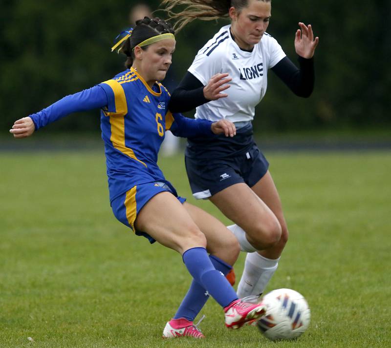 Johnsburg's Liz Smith takes a shot on goal as Harvest Christian Academy's Lizzy McLoughlin defends during the Class 1A Marian Central Girls Soccer Regional Championship match on Tuesday, May 20, 2025, at Marian Central High School in Woodstock. Smith scored the second of three goals on the play.