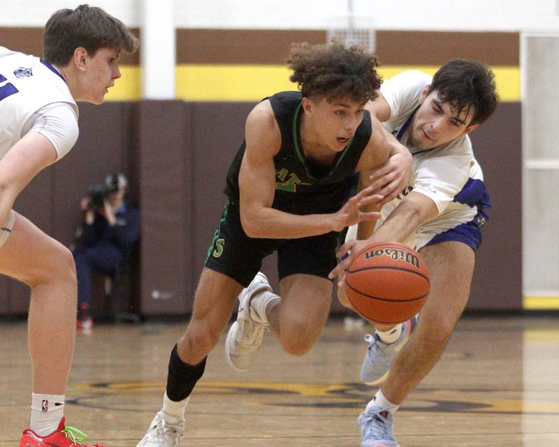 Crystal Lake South’s AJ Demirov, center, gets past Lake Zurich’s Nick Popovic, right, in Hinkle Holiday Classic boys basketball tournament game action at Jacobs High School Wednesday.