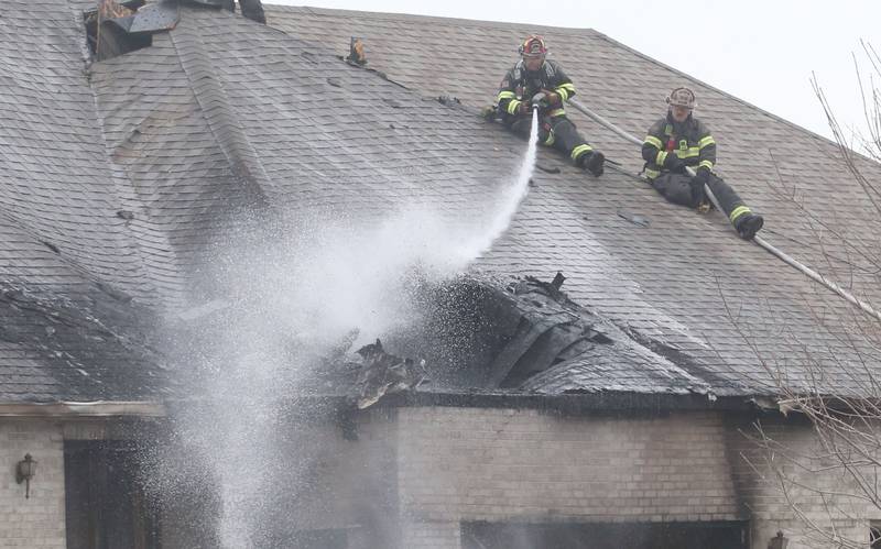 Firefighters spray water on a structure fire in the 600 block of U.S. Route 6 on Tuesday, April 1, 2025 in La Salle. Fire departments from Peru, La Salle, Utica, Troy Grove, Spring Valley, Wallace and Oglesby were dispatched just before 2:30 to a one-story dublex home.