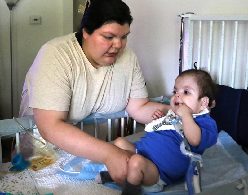 Kassandra Santos helps her daughter Marely, 1, sit up Monday, June 30, 2025, at their home in DeKalb. Marely was born with a myriad of health issues that require around-the-clock care and recently received a heart transplant.