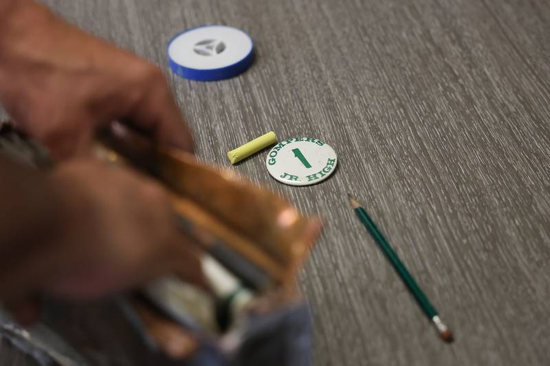 A Grompers Junior High School button from 1969 sits on a table with several other items that were found in a time capsule on Wednesday, May 1, 2026 in Joliet. In 1969 students placed items in a time capsule and sealed it inside a wall when an extension was built at Grompers Junior High School.