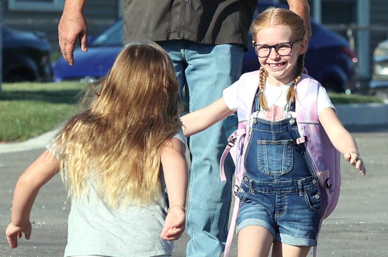 Second-graders and good friends Addison Craft (left) and Aubrey Crawford run for a hug after spotting each other Wednesday, Aug. 17, 2022, on the first day of school at North Elementary in Sycamore.