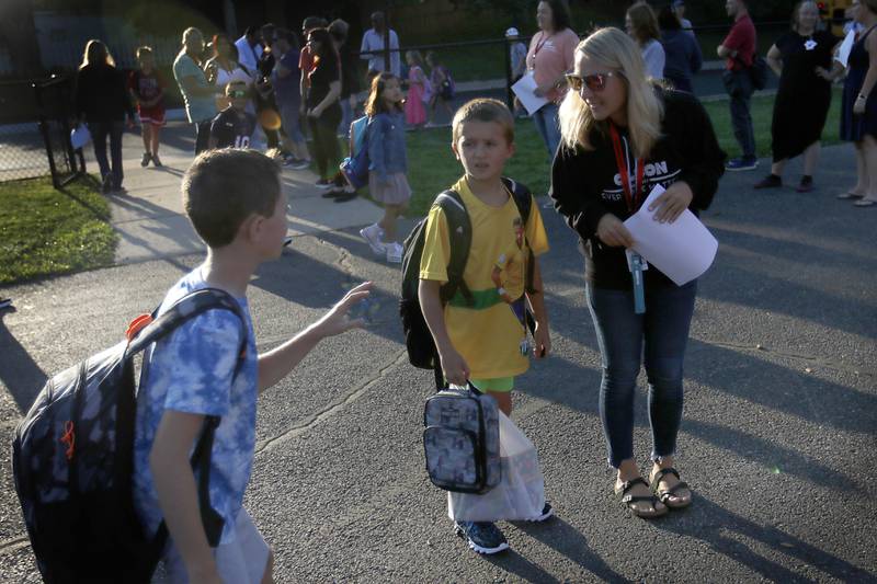 Teacher Karen McPheron helps Landon Brunetti finds his classroom line before the first day of school on Wednesday, Aug. 14, 2024, at Olson Elementary School in Woodstock.