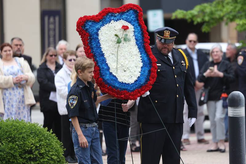 Students from Timber Ridge Middle School and a member of the Lockport Police Honor Guard carries the wreath during the Will County Law Enforcement Memorial ceremony on Thursday, May 9, 2024 in downtown Joliet.