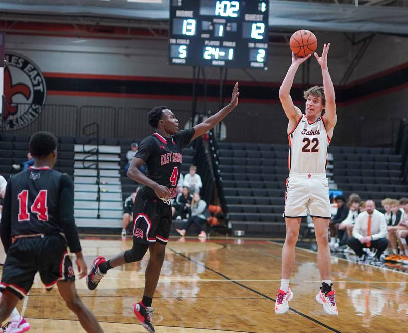 St. Charles East's Cooper Jensen (22) shoots a three pointer against East Aurora's Kenneth Cooley (4) during the 64th annual Ron Johnson Thanksgiving Basketball Tournament at St. Charles East High School on Monday, Nov 20, 2023.