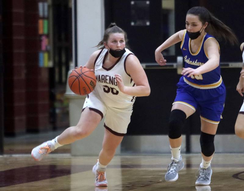 Marengo’s Addie Johnson, left, pushes the ball up court  as Johnsburg’s Macy Madsen defends during girls varsity basketball action in Marengo Thursday night.