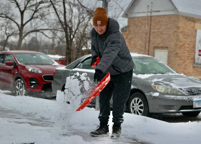 Ghonatan Pena, from DeKalb, shovels his sidewalk Wednesday, Feb. 12, 2025, in DeKalb.