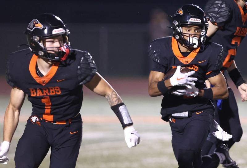 DeKalb's Xavier Dandridge follows the blocking of Talen Tate on a sweep during their game against Naperville North Friday, Sept. 22, 2023, at DeKalb High School.