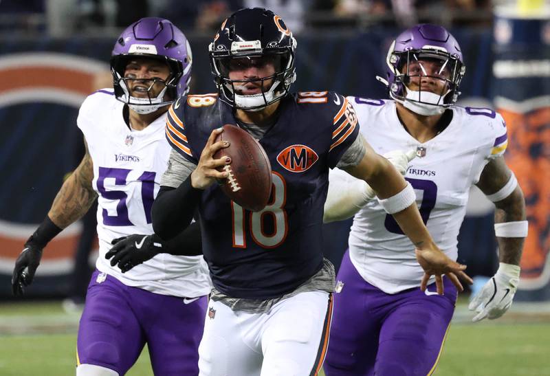 Chicago Bears quarterback Caleb Williams scrambles away from Minnesota Vikings linebacker Blake Cashman and linebacker Ivan Pace Jr. for a big gain during their game Monday, Sept. 8, 2025, at Soldier Field in Chicago.