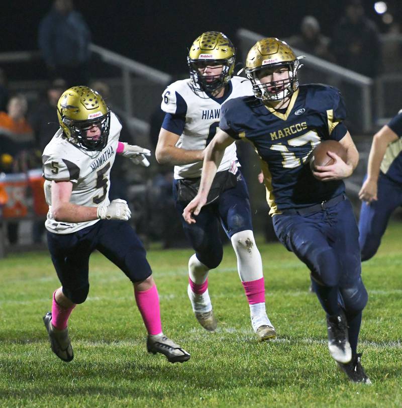 Polo's Brock Soltow out runs Hiawatha's Thomas Butler (5) and Christopher Cobb (6) for a big gain during 8-man playoff action on Friday, Oct. 28.