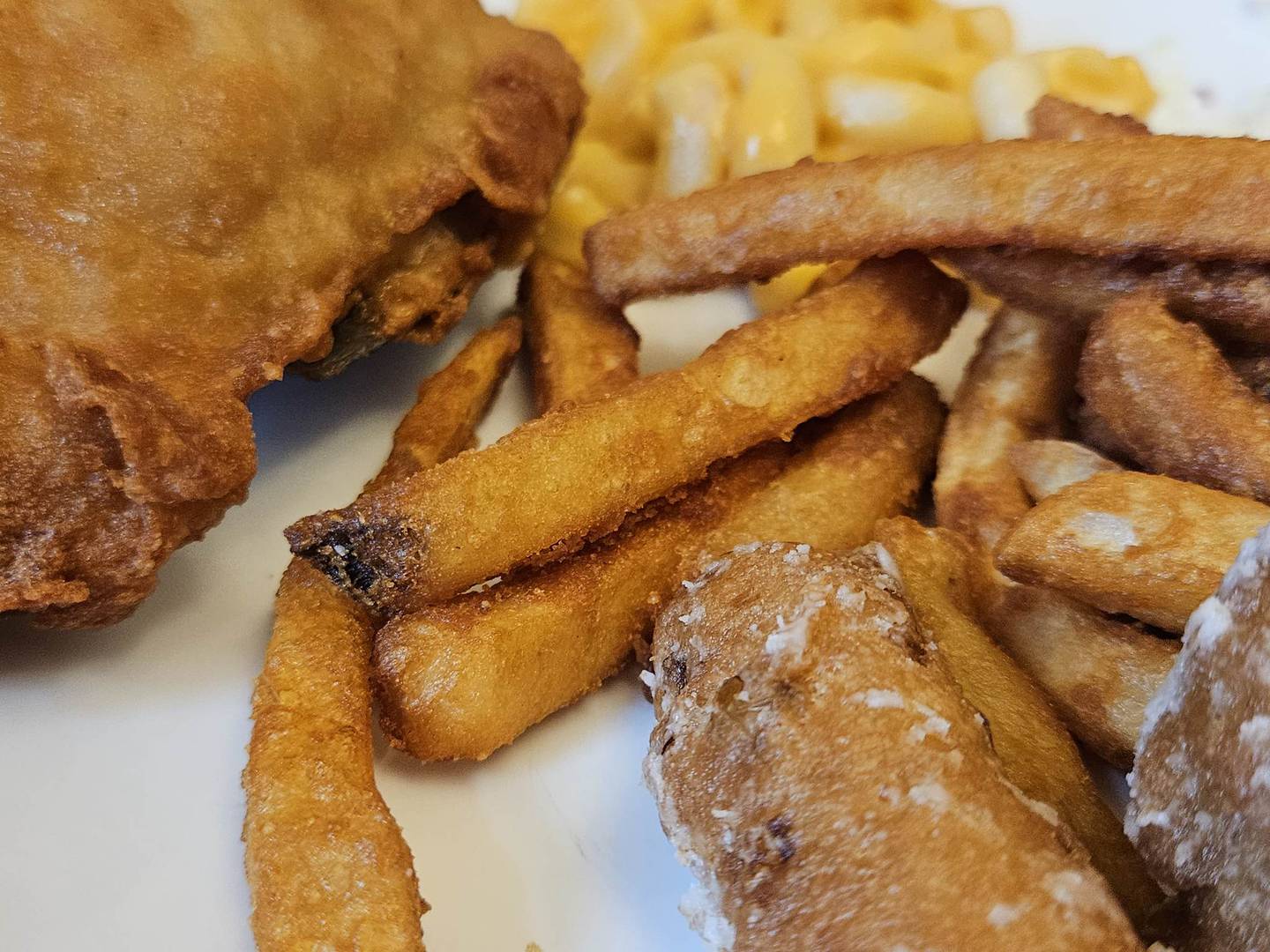 Pictured is a chicken dinner with macaroni and cheese, fries and corn fritters from the Joliet carryout location of White Fence Farm.