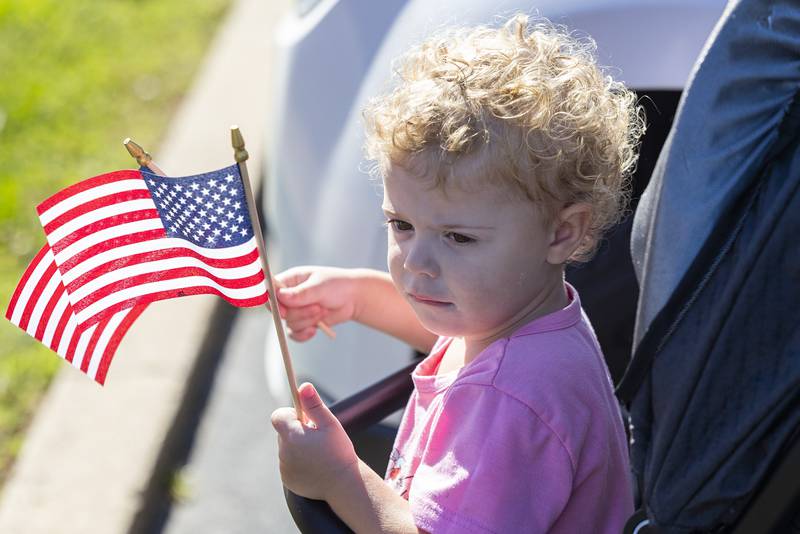 Raeleigh Popejoy, 3, waves a couple flags while waiting with her grandparents for the Vietnam Traveling Memorial Wall to arrive in Rock Falls Thursday, August 31, 2023.