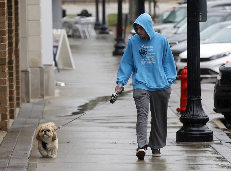 Jdyn Ross walks his dog, Chewy, along North Williams Street in Downtown Crystal Lake on Tuesday, June 13, 2023.
