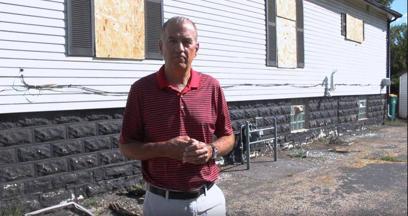 Glenn Sharp of RE/MAX Ultimate Professionals in Joliet stands outside Linda Landrey's home in Joliet. He was the listing agent for the home when it caught fire in August. He was able to sell the lot, but he is working hard to get Landrey the full value for the home, too.