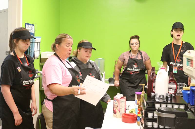 Kristie Wite, (second from left) a special education teacher at La Salle-Peru Township High School, teaches students how to take orders during the Sim-n-Savor program on Tuesday, Sept. 26, 2023 in the schools cafeteria. The coffee shop, called Cavs' Sip-n-Savor, is a student -run business serving hot or cold beverages to students and staff at the school. Students in Transitions, a post-graduation program created the business to help develope life skills.