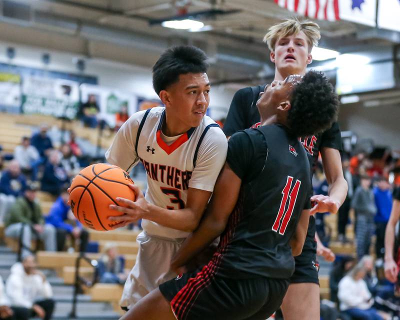 Yorkville's Christian Harrell (11) attempts to draw a charge during their basketball game between Yorkville at Oswego, Tuesday Dec 10, 2024 in Oswego.