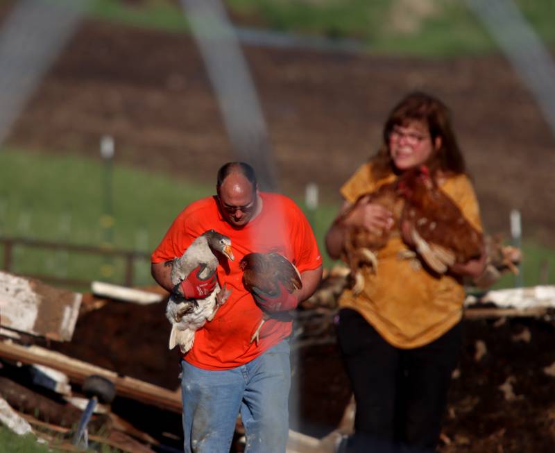 First responders and property owners tend the scene of a barn collapse along Weidner Road near Harvard on Tuesday evening.