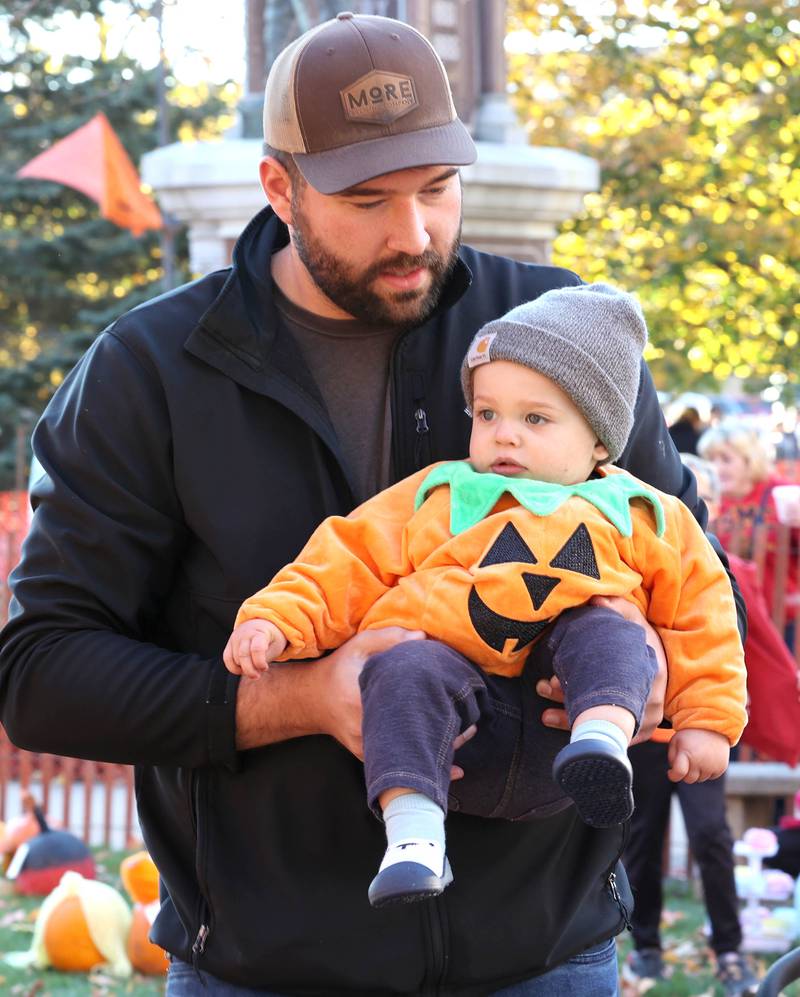 Ray Dykstra and his son Anderson, 1, from Sycamore, along with the rest of their family bring their pumpkins to set up in the display area Wednesday, Oct.26, 2022 on the DeKalb County Courthouse lawn during the first day of the Sycamore Pumpkin Festival.