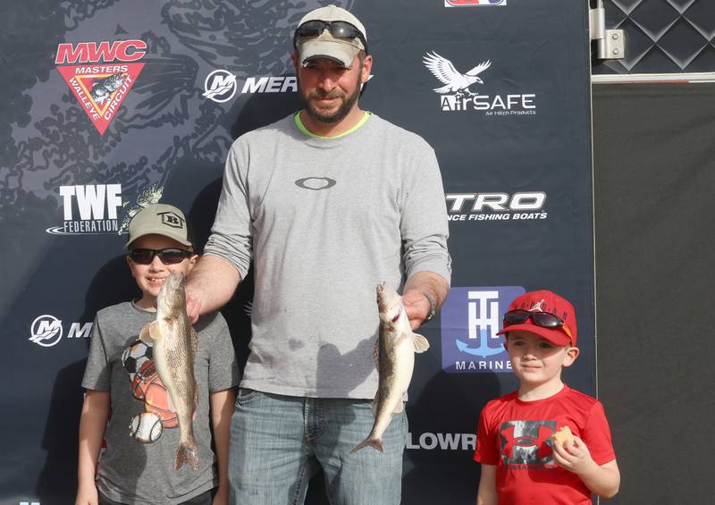 Eric Maggio of Ladd, holds his fish with his sons Owen and Grady pose for a photo caught during the annual Masters Walleye Circuit tournament on Friday, March 20, 2026 at the Spring Valley Boat Club.