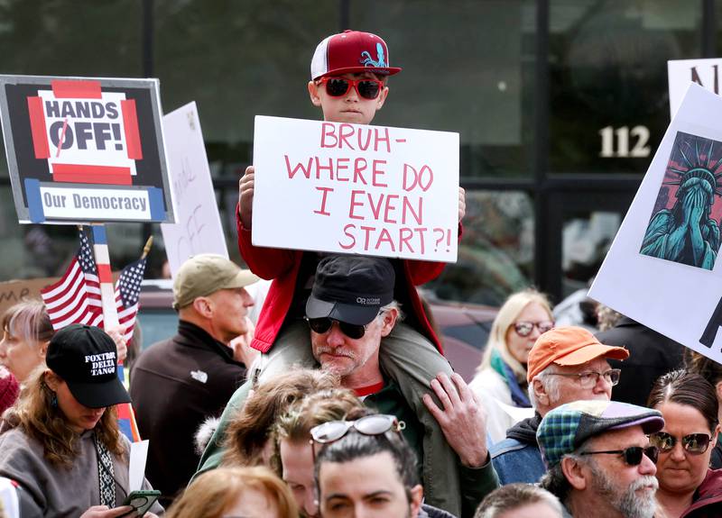 Protesters of all ages assembled Saturday, April 5, 2025, for a Hands Off! rally at Memorial Park on the corner of First Street and Lincoln Highway in DeKalb. The group gathered to protest against various policies of President Donald Trump and his administration.